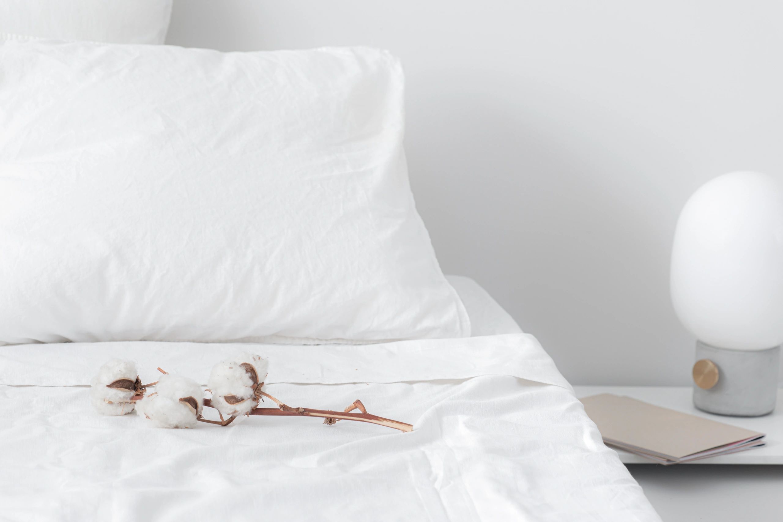 Soft white bedding styled in a calm bedroom